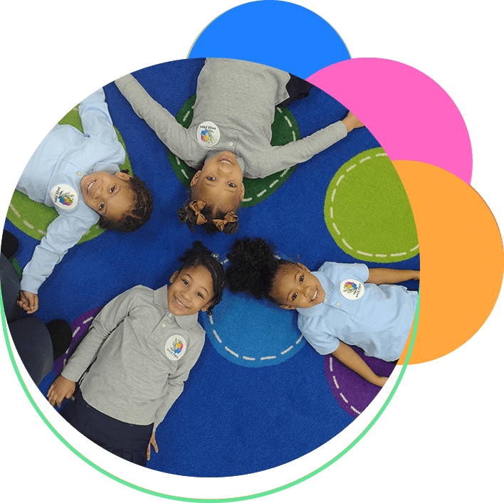 Four children lying in a circle on rug